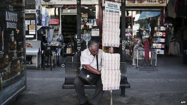 A lottery ticket seller rests at a bus-stop in Athens