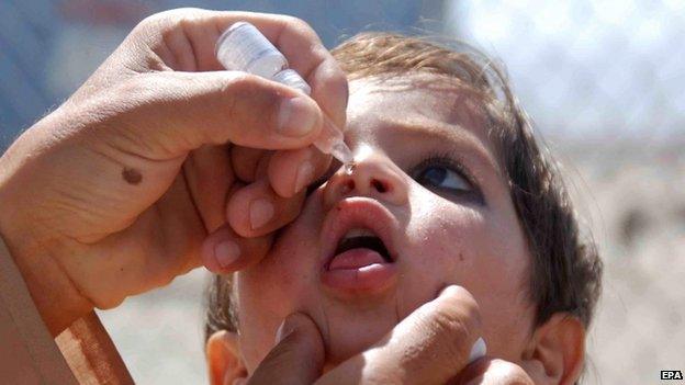 A health worker administers a polio vaccine to a child near the Afghan border in Chaman, Pakistan (22 May 2015)