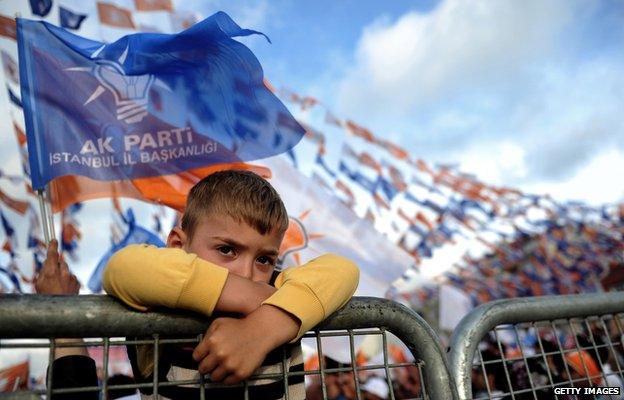 A child stands behind a fence during a campaign rally by Turkish Prime Minister and leader of the ruling Justice and Development Party (AKP) in Istanbul on June 2, 2015.