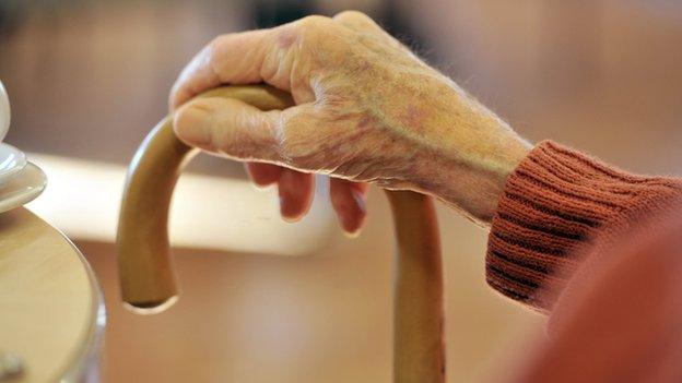 Elderly person holding a walking stick