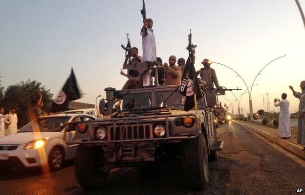 Islamic State in Iraq and the Levant (Isis) militants drive through Mosul in a captured Humvee (23 June 2014)