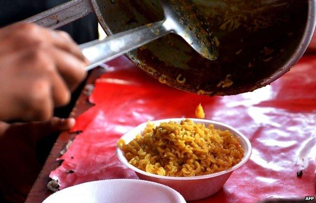 An Indian youth prepares Nestle "Maggi" instant noodles at his makeshift roadside food stall on the outskirts of New Delhi on June 3, 2015.