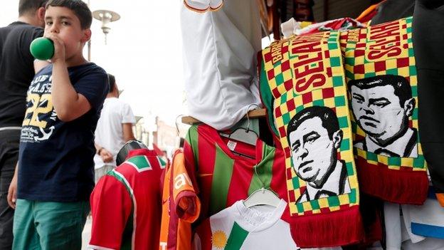 A young boy walks near election-themed scarves showing a depiction of leader of the Peoples" Democratic Party (HDP) Selahattin Demirtas, in Diyarbakir