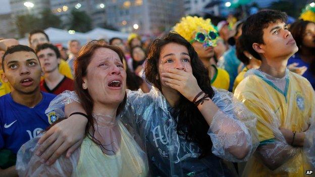 Brazil soccer fans cry as they watch their team lose 7-1 to Germany at a World Cup semi-final match in Rio de Janeiro, Brazil, Tuesday, July 8, 2014