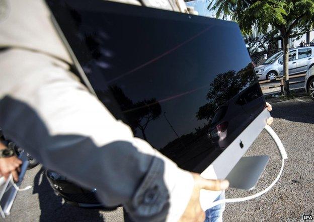 A police officer carries a computer during a search operation in Rome, Italy, 4 June 2015