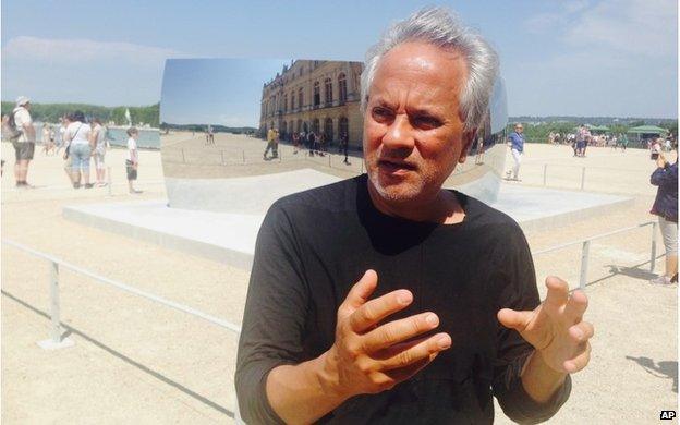 Artist Anish Kapoor answers questions during an interview with the Associated Press during the presentation of his exhibition in the gardens of the Chateau de Versailles near Paris, France, Friday, June 5, 2015