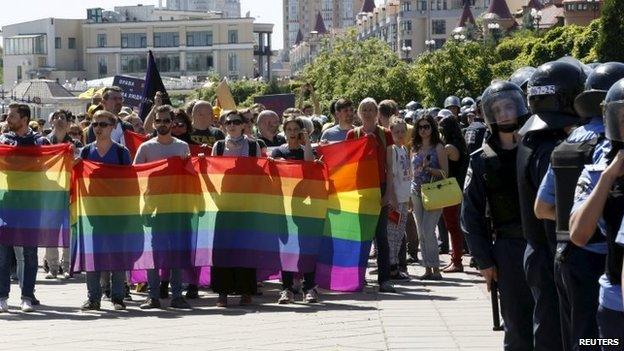 Participants of the Equality March rally in Kiev, as police stand guard