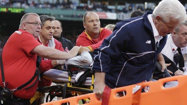 A female fans receives treatment during a game between Boston Red Sox and Oakland Athletics