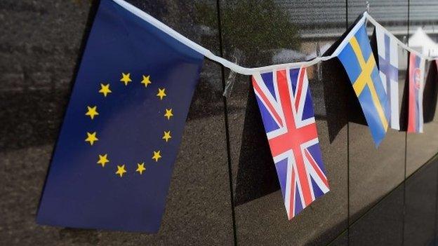 An European flag and a British flag stand next to each others outside the European Commission