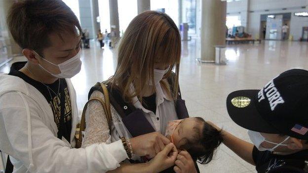 Tourists wear masks as a precaution against the Mers virus at the Incheon International Airport on 6 June