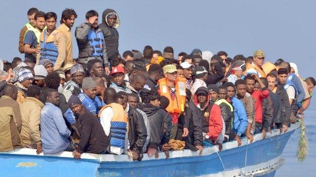 Migrants stranded on a boat, thirty miles off the Libyan coast as they are rescued by Royal Marines