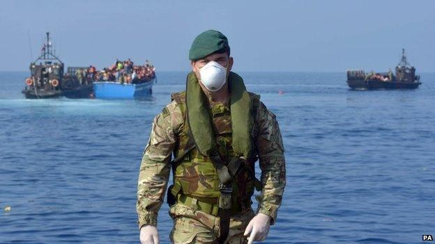 Royal Marines and servicemen from HMS Bulwark help rescue migrants stranded on a boat, thirty miles off the Libyan coast