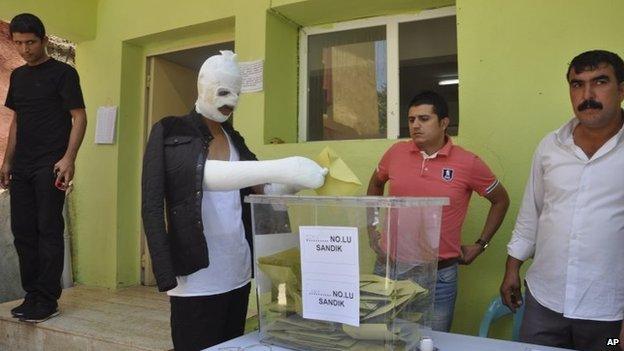 A man, wounded in Saturday"s attack against the pro-Kurdish Peoples" Democratic Party (HDP) rally in Diyarbakir, southeastern Turkey, that left two people killed and scores wounded, casts his vote Sunday, June 7, 2015