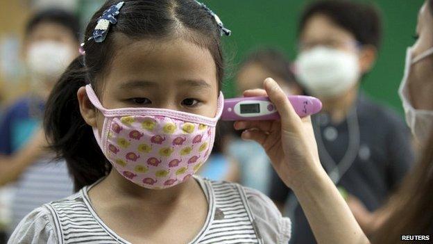 A pupil receives a temperature check at an elementary school in Seoul - 8 June 2015