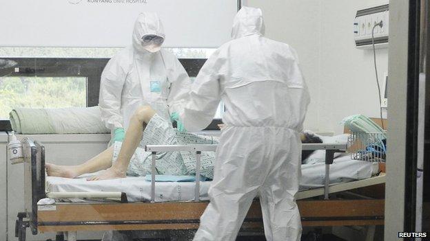 Health care workers in full protective gear check a patient who is infected with Middle East Respiratory Syndrome (MERS) at a hospital in Daejeon, South Korea, 8 June 2015.