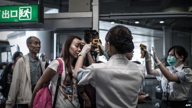 Passengers get their temperature checked at the Hong Kong international airport - 5 June 2015