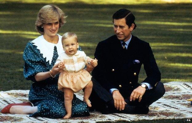 The Prince and Princess of Wales amuse baby Prince William on a rug in the grounds of Government House in Auckland, New Zealand