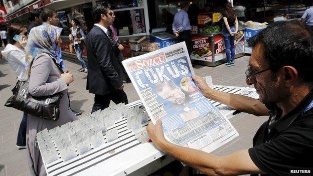 A lottery ticket vendor reads a Turkish newspaper published with an headline reads "downfall" and a portrait of Turkey"s President Tayyip Erdogan in Ankara, Turkey, June 8, 2015