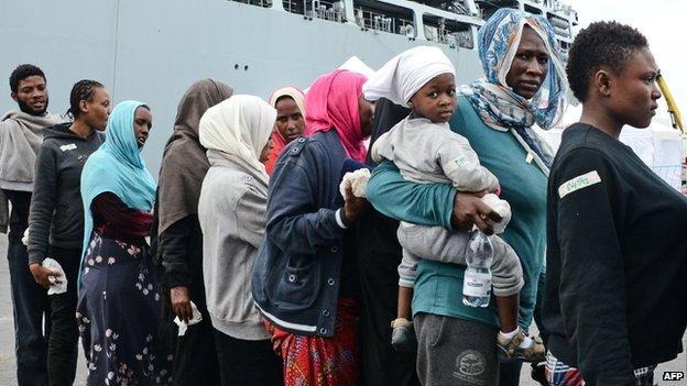 Migrants disembark from the Royal Navy ship HMS "Bulwark" upon their arrival in the port of Catania