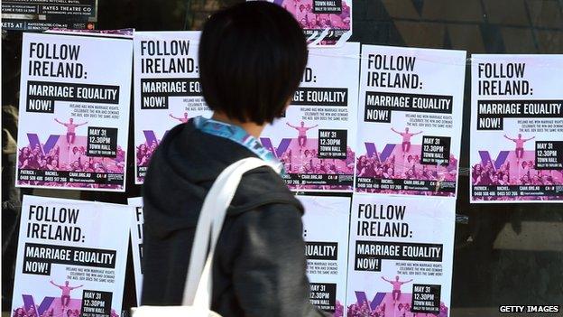 A woman walks past posters in Sydney advertising a rally supporting same-sex marriages, June , 2015