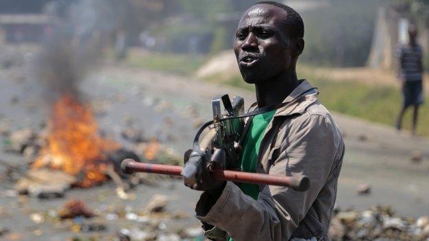 An opposition demonstrator points a mock gun made from wood towards soldiers and tells them it is shameful to shoot on people who cannot defend themselves, in the Ngagara neighbourhood of the capital Bujumbura, in Burundi Wednesday, 3 June 2015