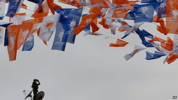 Turkish security officer under a banner of AKP flags