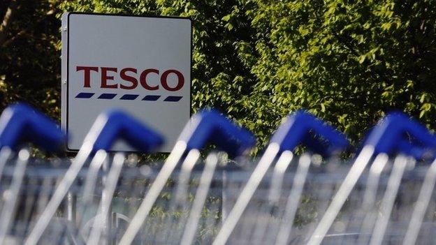 Shopping trolleys are seen lined up at a Tesco supermarket