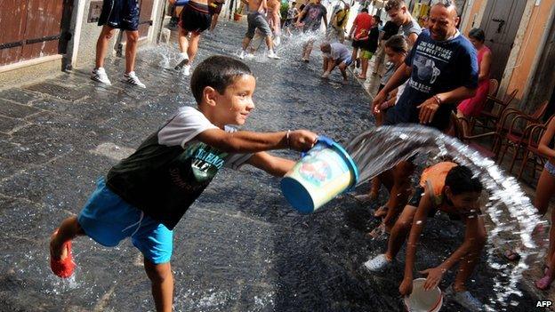 An Italian boy throwing a bucket of water