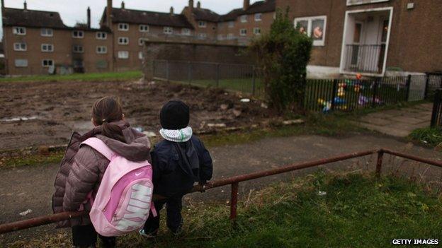 Children sitting near poor housing