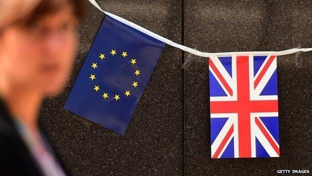 An European flag and a British flag stand next to each others outside the European Commission