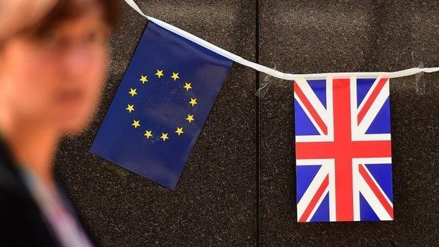 An European flag and a British flag stand next to each others outside the European Commission