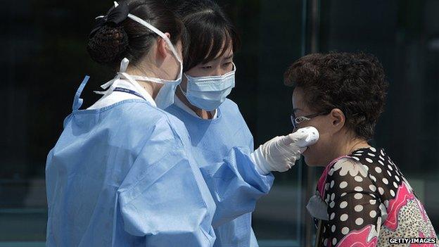 Medical staffs check the temperature of a visitor at Seoul Medical Center