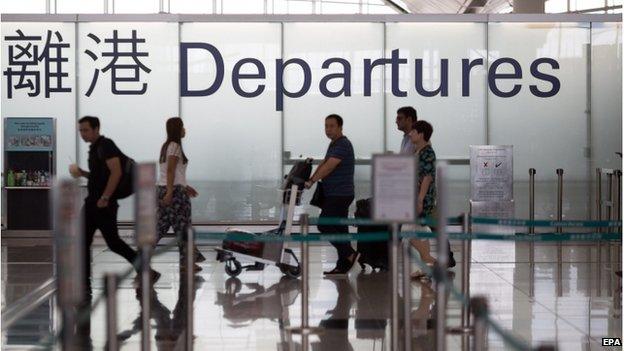 Travellers walk in the departure hall of the Hong Kong International Airport in Hong Kong, China, 9 June 2015.