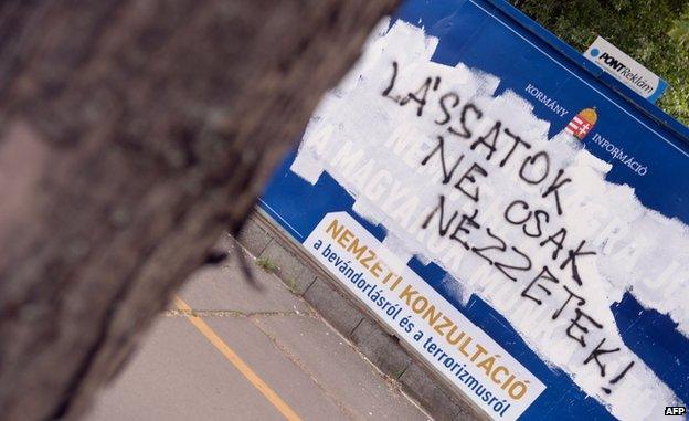 Anti-immigration poster defaced with the slogan: "See it not only look at it"