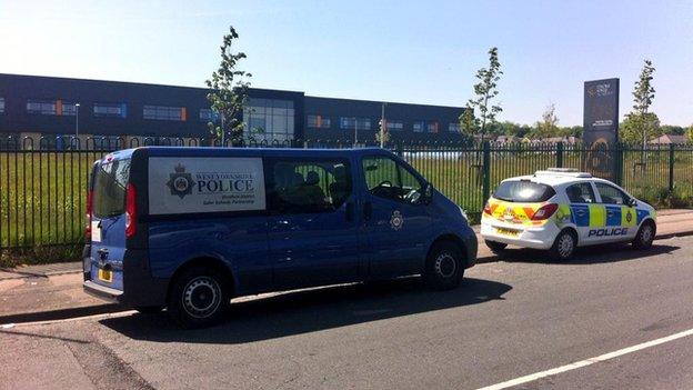 Police vehicles are parked outside the school on Northside Road