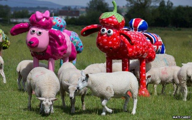 Shaun the Sheep sculptures in a field with real sheep