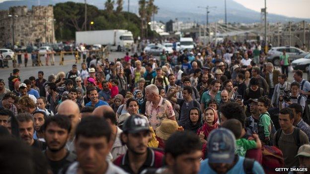 Hundreds of migrants and some tourists board a ferry on the Greek island of Kos to go to Athens