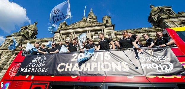 Glasgow Warriors players with the Pro12 trophy on their open-top bus