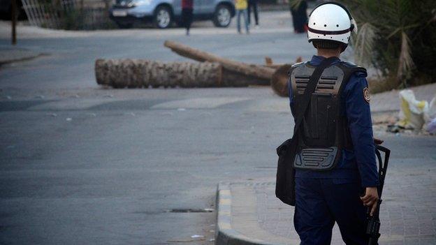 A Bahraini riot police force officer looks on as he tries to disperse an anti-government protest in the village of Musalla, west of Manama on July 20, 2012