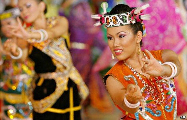 A dancer wearing a traditional tribal costume from Malaysian Borneo performs during the Citrawarna (Colours of Malaysia) festival parade in downtown Kuala Lumpur, late 8 July 2006.