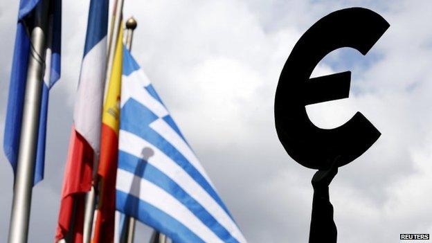 A Greek flag flies behind a statue to European unity outside the EU Parliament in Brussels