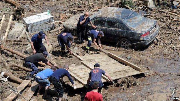 Rescuers and local residents collect debris at a flooded area in the Georgian capital Tbilisi on 15 June 2015.