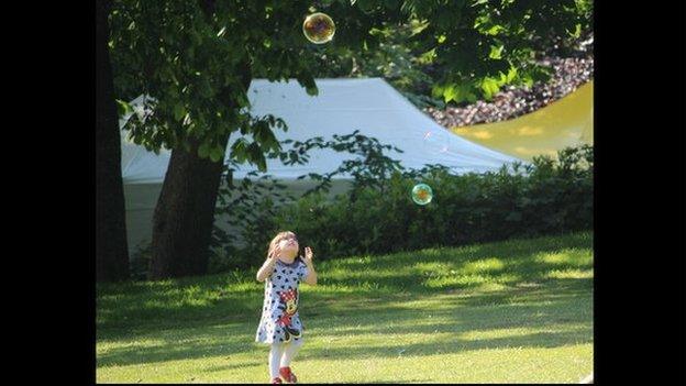 A young girl chases bubbles