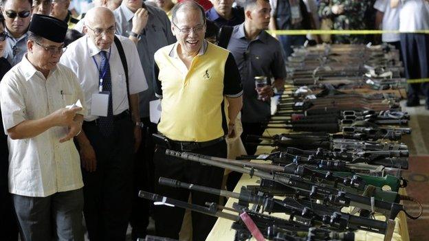 Philippine President Benigno Aquino III (3-L) and Moro Islamic Liberation Front Chairman Al Haj Murad Ebrahim (L) inspect surrendered firearms from the members of rebel group Moro Islamic Liberation Front (MILF) during the first phase of the decommissioning of rebel weapons in the town of Sultan Kudarat, Maguindanao province, Southern Philippines, 16 June 2015.