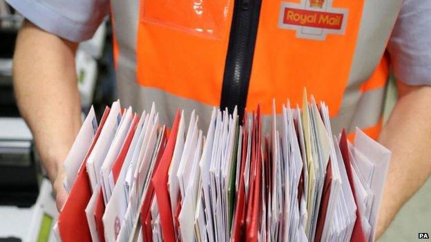 Royal Mail worker holding letters