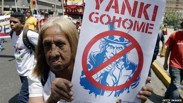 A supporter of Venezuelan president Nicolas Maduro holds a poster of Uncle Sam to protest against the United States, during a demonstration in Caracas on 12 March, 2015.