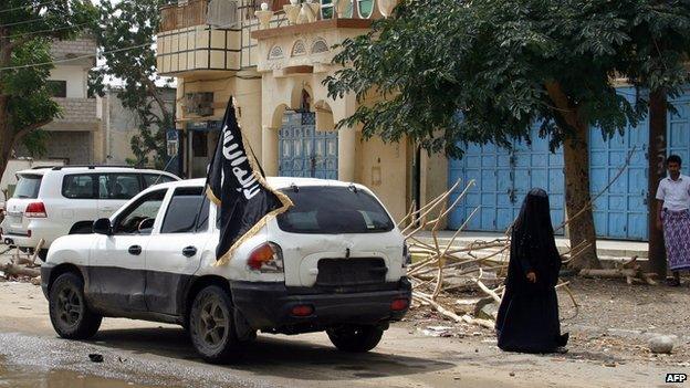 A vehicle flying the flag of Ansar al-Sharia, an affiliate of AQAP, drives through the town of Jaar, in Abyan province, Yemen (25 January 2012)