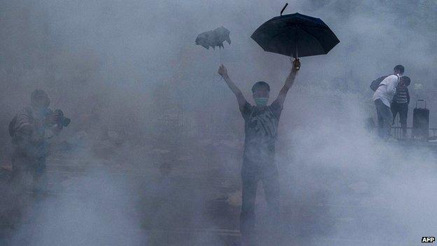 A pro-democracy demonstrator gestures after police fired tear gas towards protesters near the Hong Kong government headquarters 28 September 2014