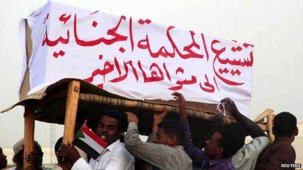 Supporters of Sudanese President Omar al-Bashir (not in the picture) carry a mock coffin representing the International Criminal Court at the airport in the capital Khartoum, Sudan, 15 June 2015