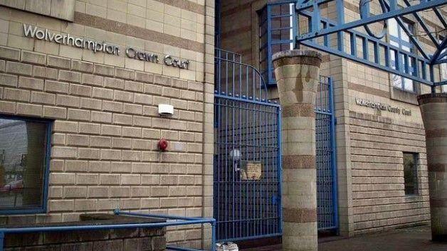A brick building with a blue gate. Lettering on the wall reads "Wolverhampton Crown Court".
